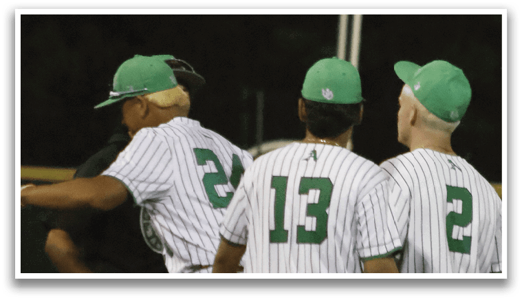 A group of baseball players wearing green hats and white uniforms. Description generated by AI