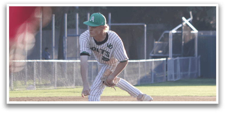 A baseball player in a green hat and white uniform is pitching a ball. Description generated by AI