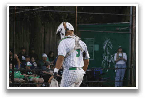 A baseball player wearing a white and green uniform. Description generated by AI
