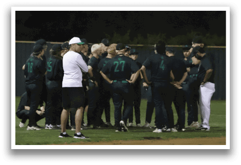 A group of people wearing green shirts and white pants standing on a baseball field. Description generated by AI