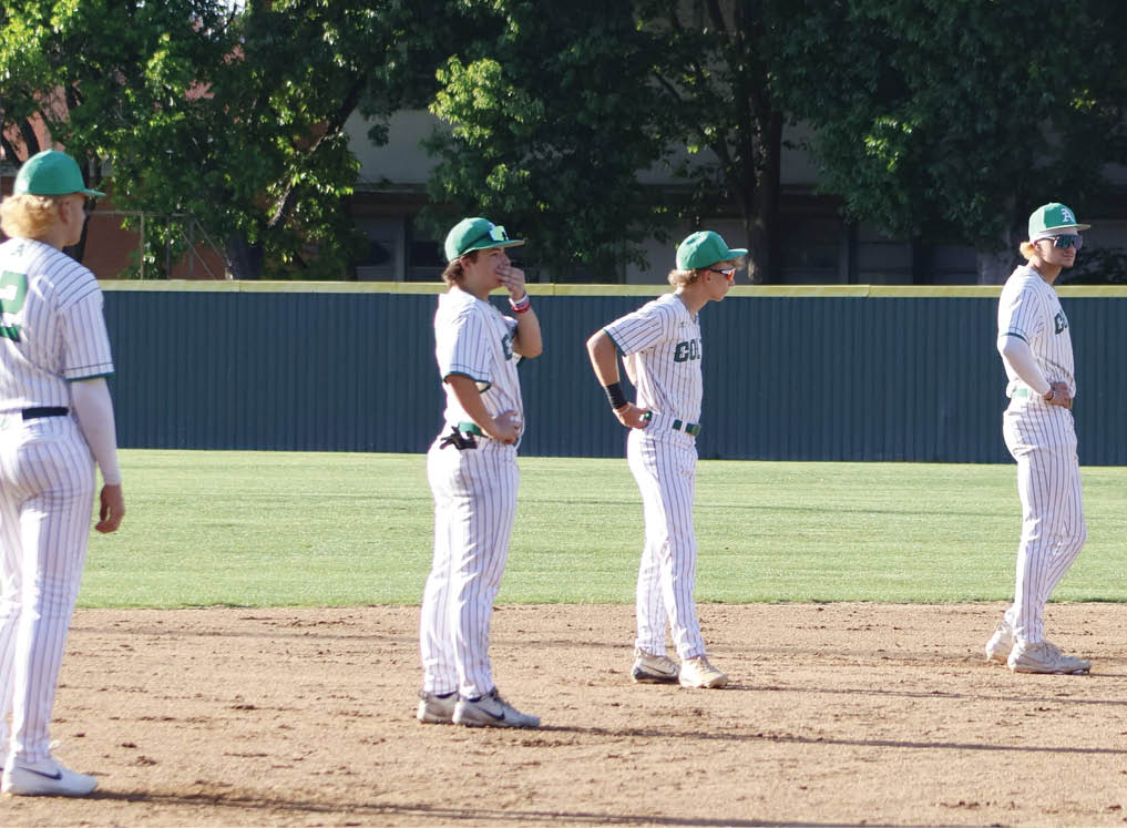 A group of baseball players standing on the field. Description generated by AI