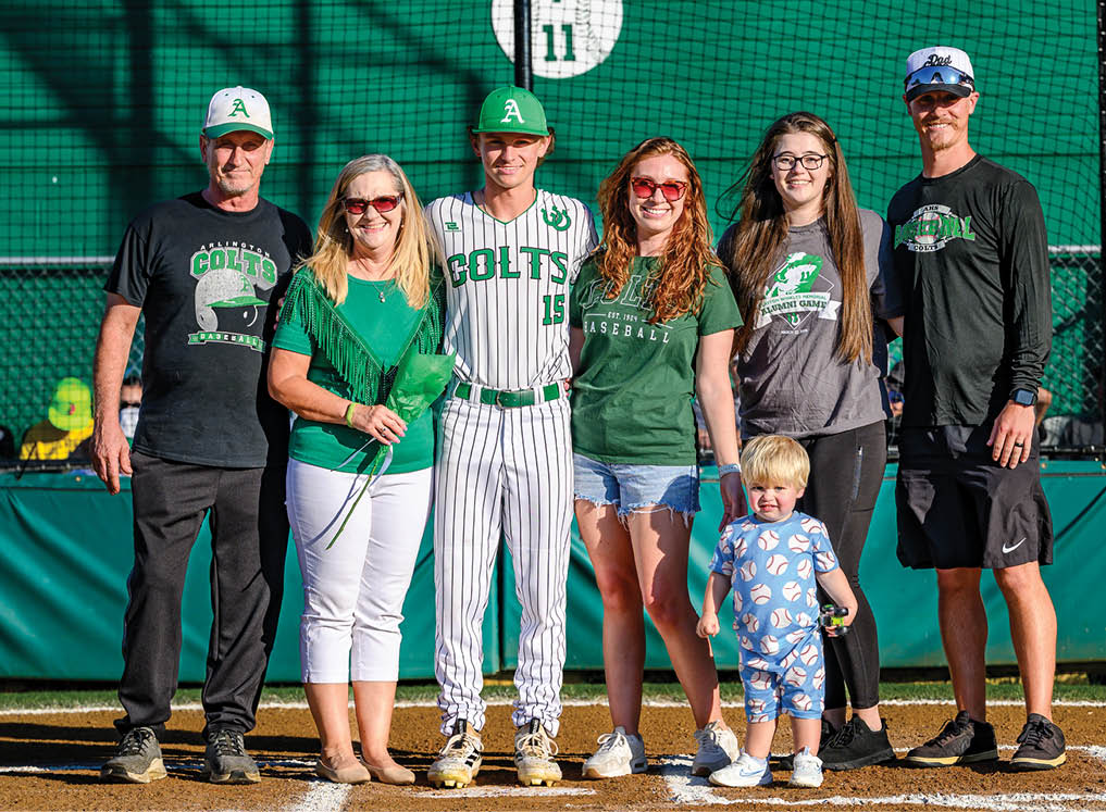 A group of people standing on a baseball field. Description generated by AI