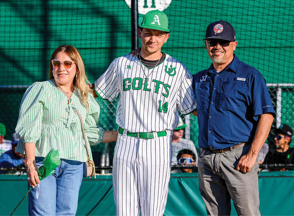 A man and woman are standing on a baseball field with a man in a baseball uniform. Description generated by AI