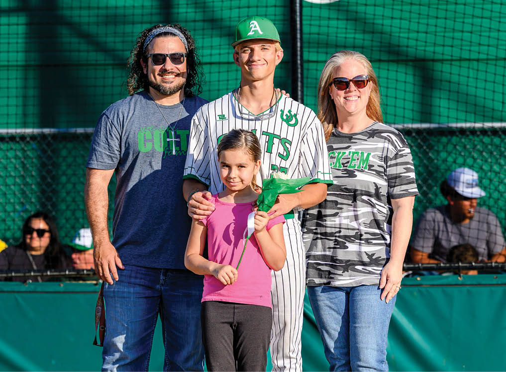 A man, woman, and girl are standing on a baseball field. Description generated by AI
