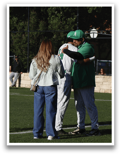 A group of people standing on a baseball field. Description generated by AI