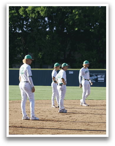 A group of people standing on a baseball field. Description generated by AI
