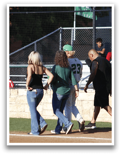 A man and woman standing on a baseball field. Description generated by AI