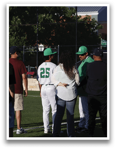 A man wearing a baseball uniform walks on a field. Description generated by AI