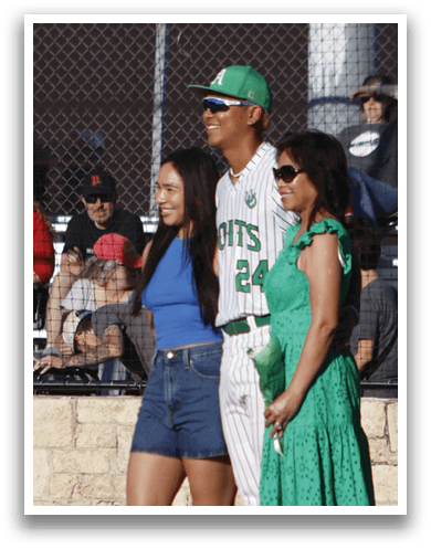 A group of people standing on a baseball field. Description generated by AI