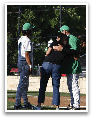 A group of people standing on a baseball field. Description generated by AI