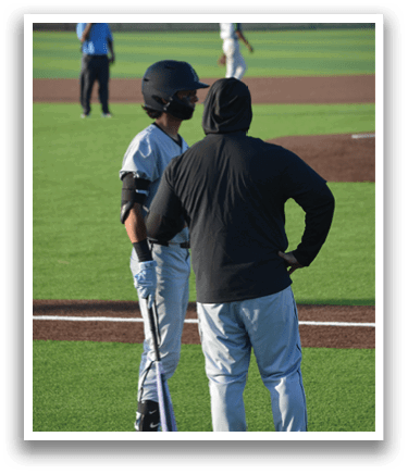 Two baseball players on a field, one holding a bat and the other talking to him. AI generated content