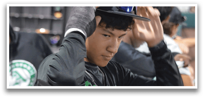 A man wearing a black shirt and a green hat is adjusting his hat. AI generated content