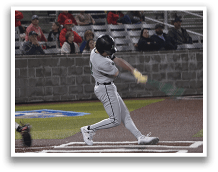 A baseball player in a grey uniform is swinging a bat at a ball. AI generated content