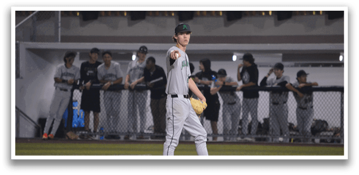 A baseball player stands on the pitcher's mound, wearing a gray uniform and a green hat. He is holding a baseball in his hand, preparing to throw it. The player is surrounded by a group of other players, some of whom are also wearing baseball gloves. The scene takes place on a baseball field, with a bench visible in the background. AI generated content