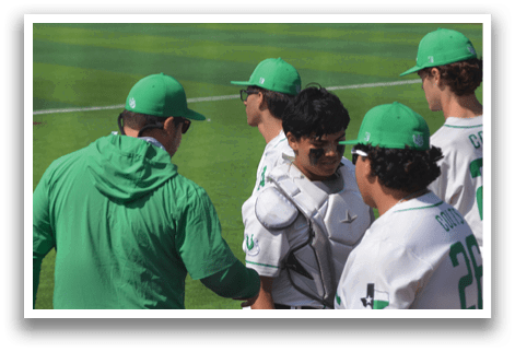 A group of baseball players wearing green hats and white uniforms standing on a field. AI generated content