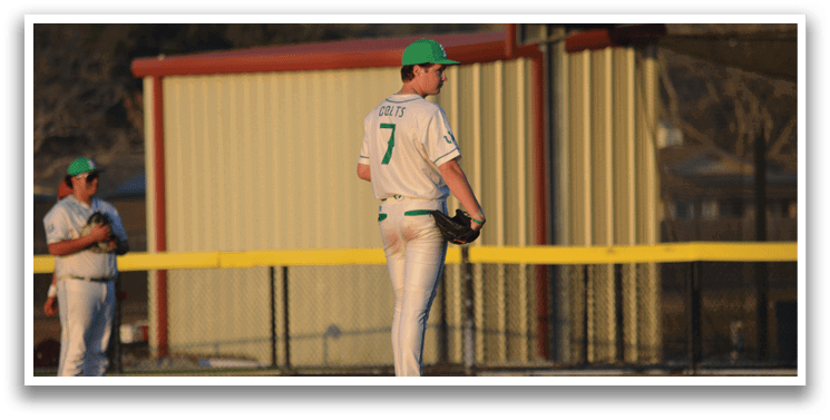 A baseball player wearing a green hat and a white jersey stands on the pitcher's mound, holding a baseball glove. AI generated content