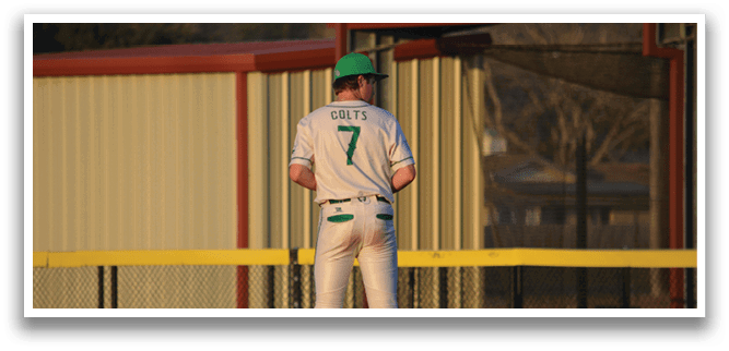 A baseball player wearing a green and white uniform stands on the pitcher's mound. AI generated content