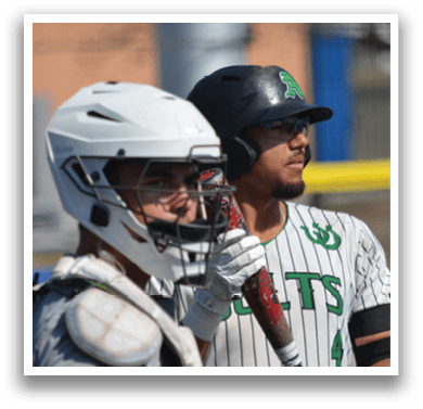 Two baseball players are standing on a field, one holding a bat and the other wearing a helmet. AI generated content