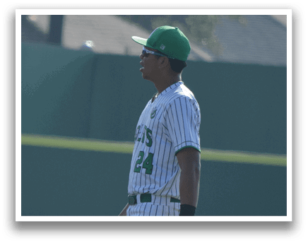 A baseball player in a green and white uniform is walking on the field. AI generated content