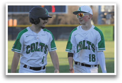 Two baseball players wearing green and white uniforms are talking to each other. AI generated content
