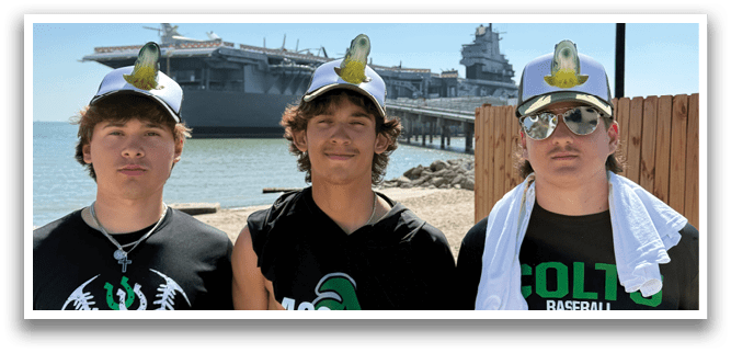 Three young men pose for a picture in front of a battleship. AI generated content