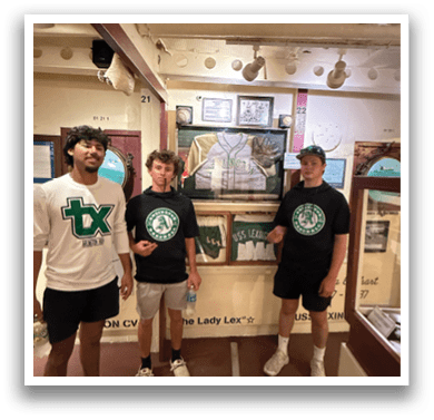 Three young men wearing black shirts and white shorts pose for a picture in front of a painting. AI generated content