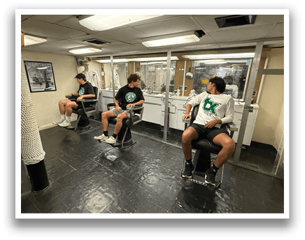 Three men are sitting in chairs in a room, getting haircuts. AI generated content