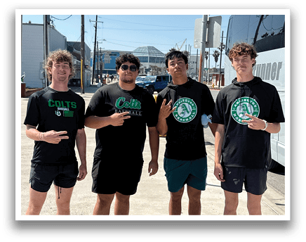 Four men wearing black shirts and shorts pose for a picture. AI generated content