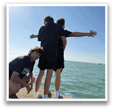 Three people are standing on a rock near the water. AI generated content