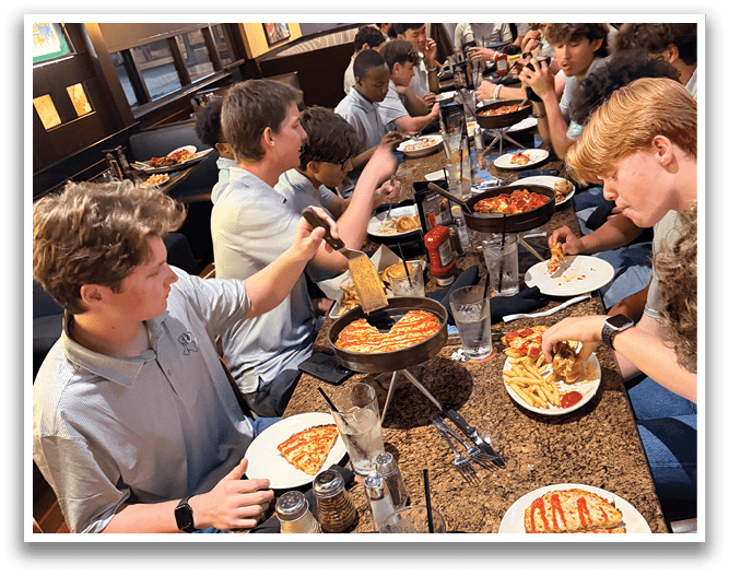 A group of people are sitting around a table with pizza and drinks. AI generated content