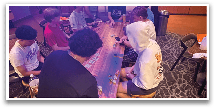 A group of people are sitting around a table playing a game. AI generated content