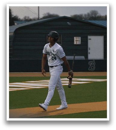 A baseball player wearing a green and white uniform walks across the field. AI generated content