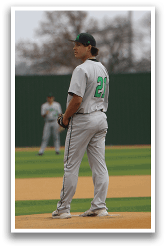 A baseball player stands on the pitcher's mound, wearing a white uniform and a green hat. AI generated content