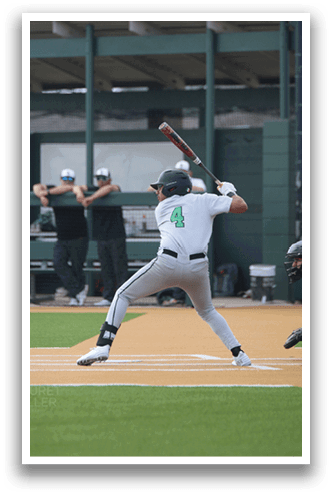 A baseball player in a white uniform is swinging a bat at a ball. AI generated content
