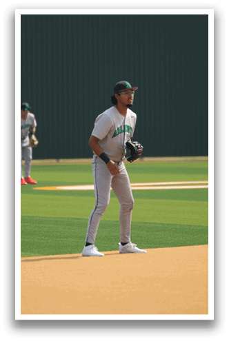 A baseball player in a white uniform stands on the field, holding a baseball glove. AI generated content