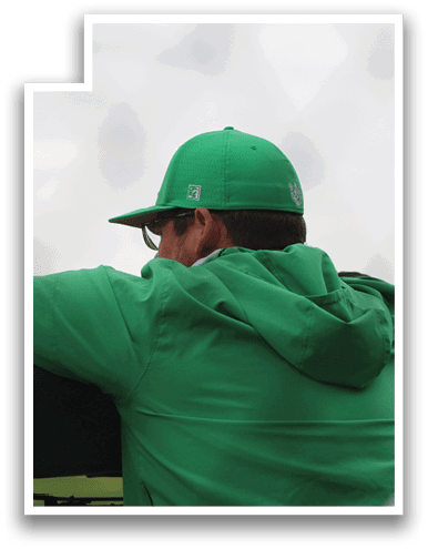 A man wearing a green hat and jacket is sitting on a bench. AI generated content