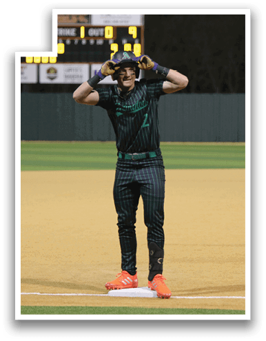 A baseball player wearing a green shirt and black pants stands on the field with his hands on his head. AI generated content