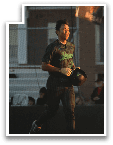 A baseball player wearing a green shirt and black pants is holding a baseball glove and walking on a field. AI generated content