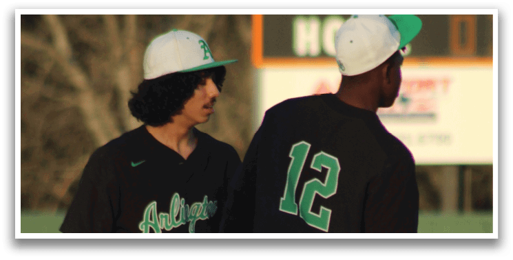 Two baseball players wearing green and white uniforms are standing on the field. One player is holding a baseball glove. AI generated content
