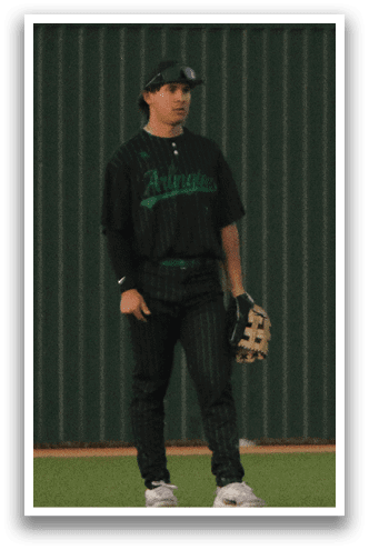 A baseball player in a black shirt and green hat stands on a field. AI generated content