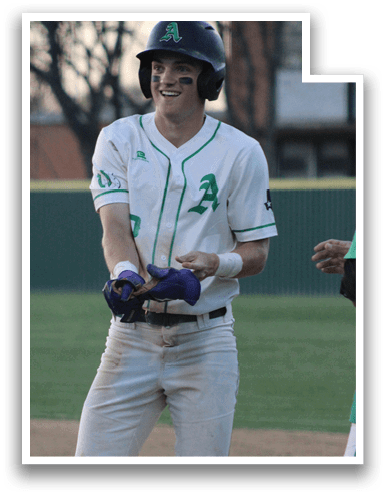 A baseball player wearing a green and white uniform stands on the field with his hands on his hips. AI generated content