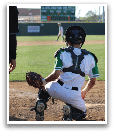 A baseball player in a catcher's position, wearing a helmet and a green and white uniform, is ready to catch the ball. AI generated content