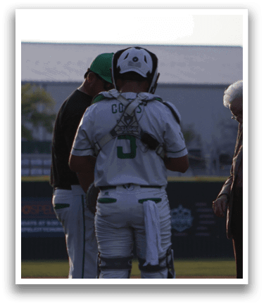 A man and woman are standing on a baseball field. Description generated by AI