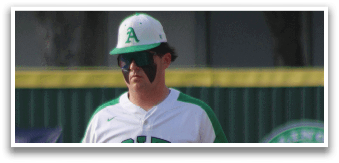 A baseball player wearing a green and white uniform. Description generated by AI