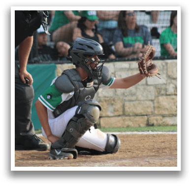 A baseball catcher wearing a green and white uniform. Description generated by AI
