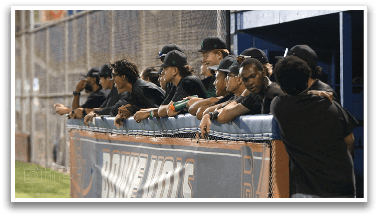 A baseball player is running towards home plate, while a teammate is trying to tag him out. AI generated content
