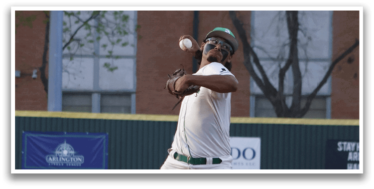 A baseball player in a white uniform is pitching a ball. Description generated by AI