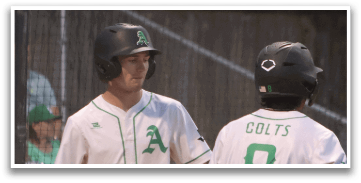 Two baseball players wearing green and white uniforms. Description generated by AI