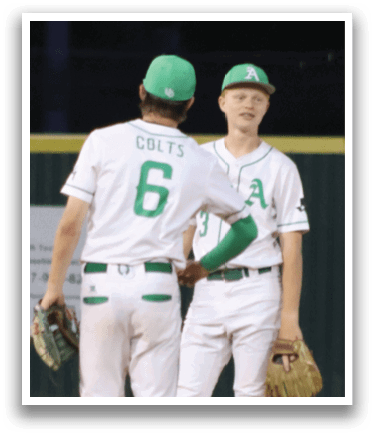 A man wearing a green hat and a black shirt is holding a baseball. Description generated by AI
