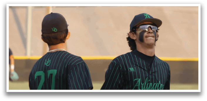 Two baseball players wearing green and black uniforms. Description generated by AI